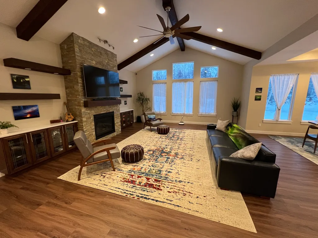 A beautiful living room with windows overlooking the mat-su valley.