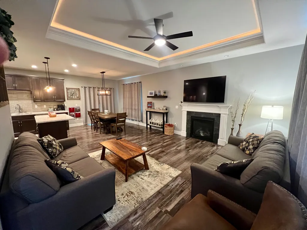 A clean living room with an american flag hanging above the mantle